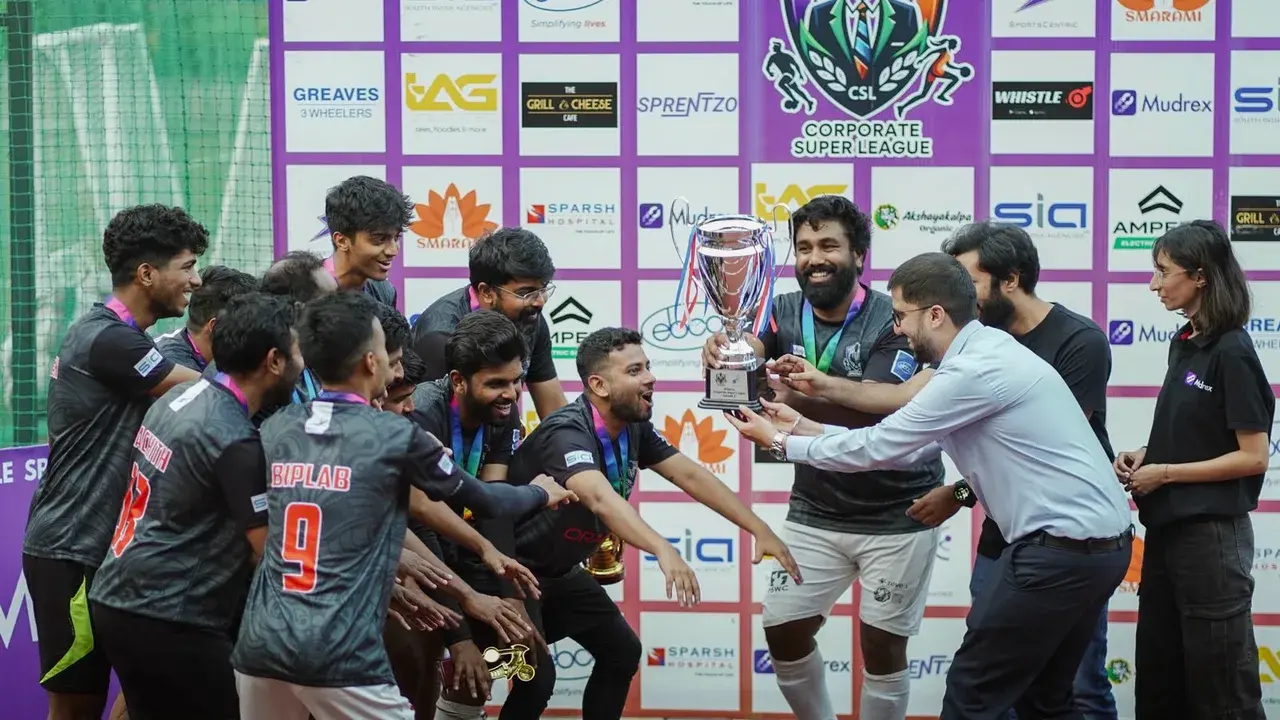 Corporate sports teammates gathered around a trophy presentation.