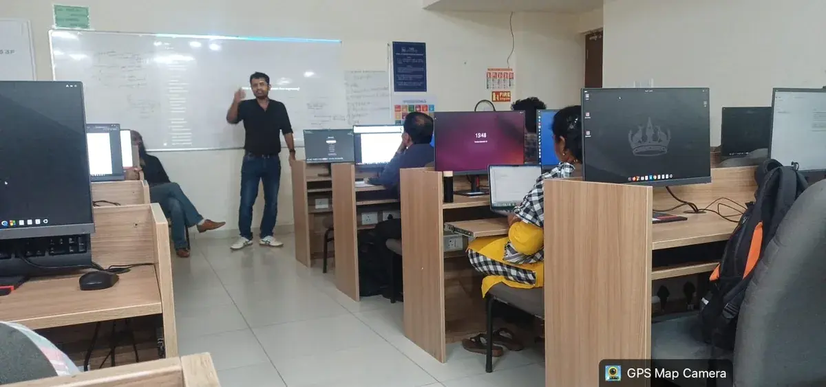 A facilitator discussing the session with faculty seated at classroom computers