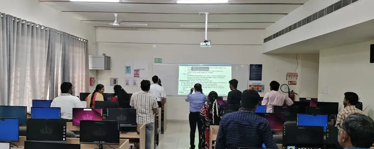 Faculty standing together around the projected screen during the Day 4 workshop