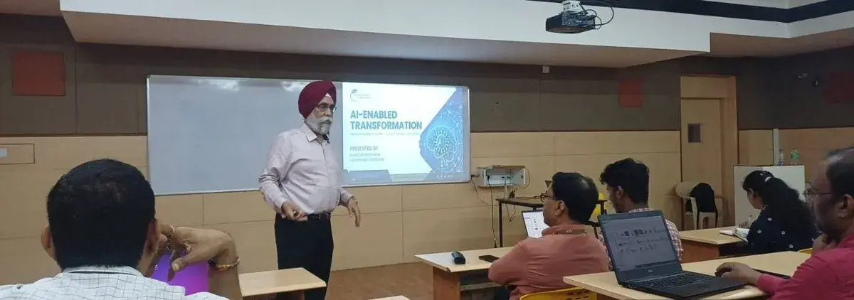 Barinder Sethi speaking beside the projected AI-enabled transformation presentation